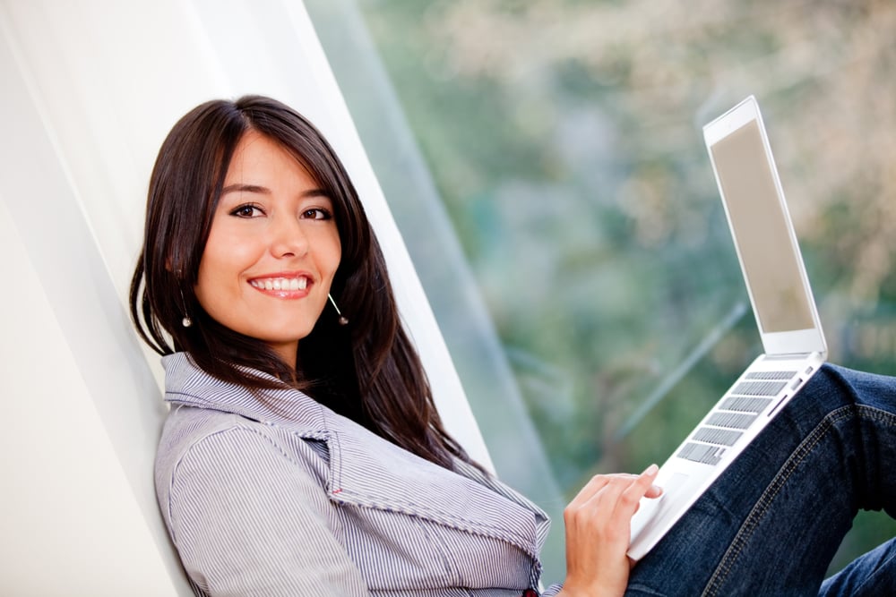 Woman managing her online business at home and smiling
